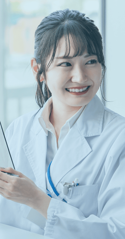 笑顔の女性医師が資料を手に持っている