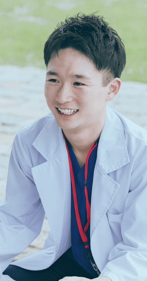 優しい表情で座っている男性医師