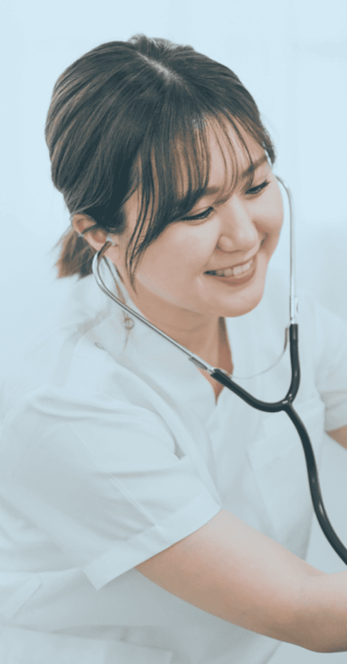 笑顔で女性医師が聴診器を使用している様子