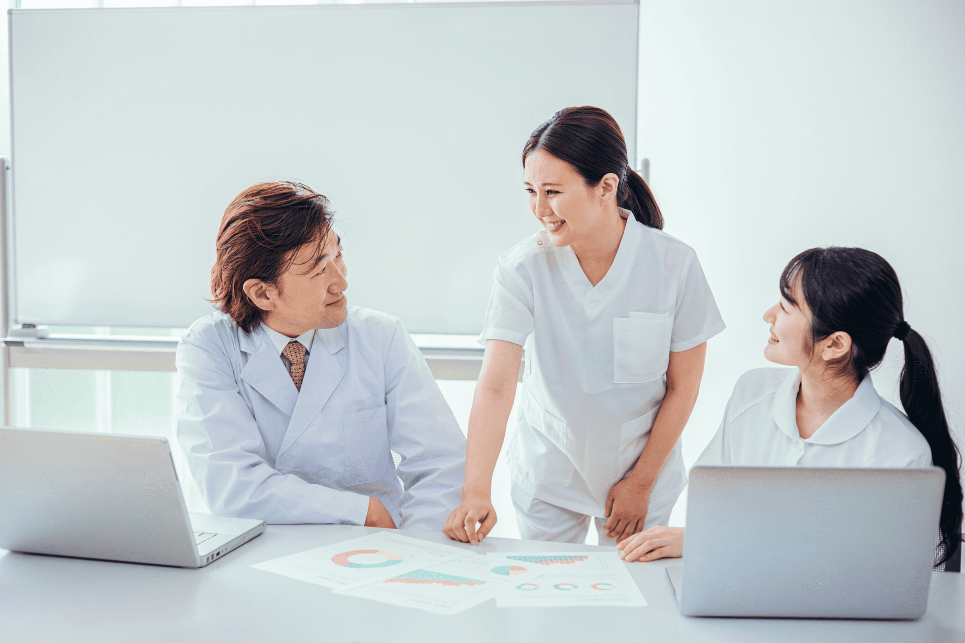 医師と看護師が会議室で笑顔で話し合っている様子