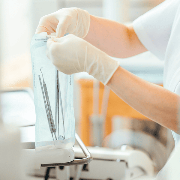 歯科衛生士が滅菌パックに入った歯科治療器具を準備している様子