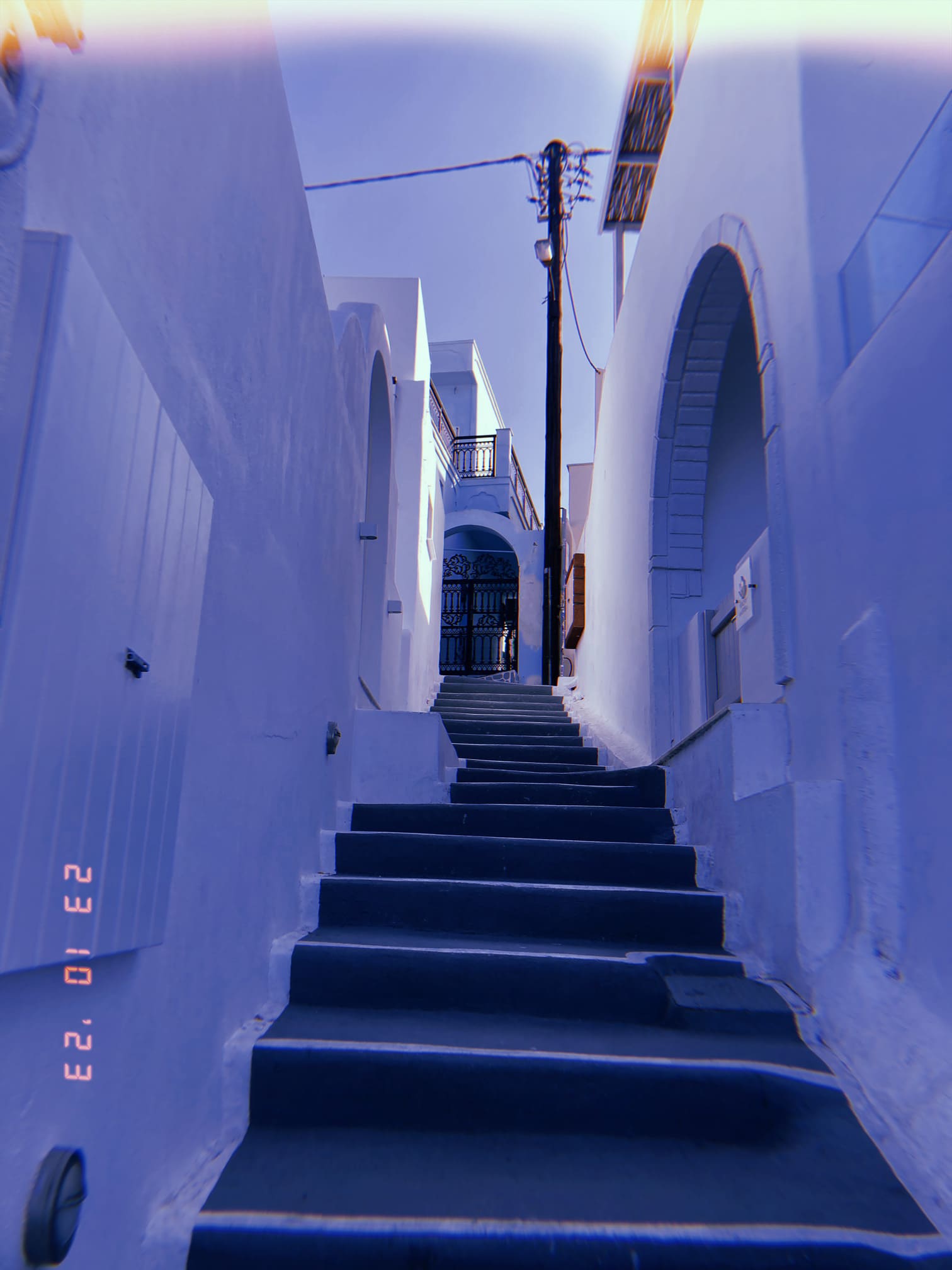 白壁に囲まれた狭い路地と階段