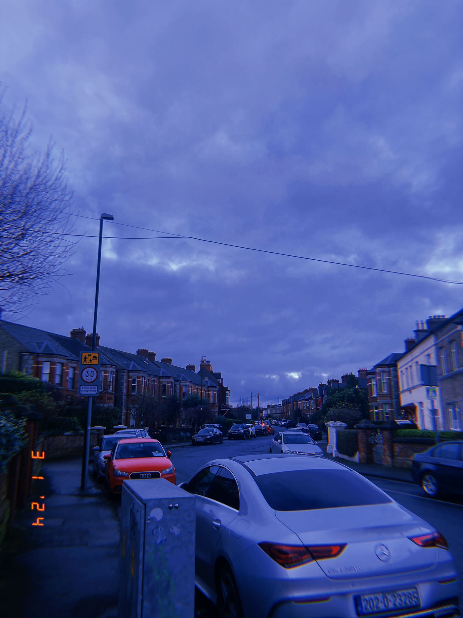 夕方の住宅街の通りと車列