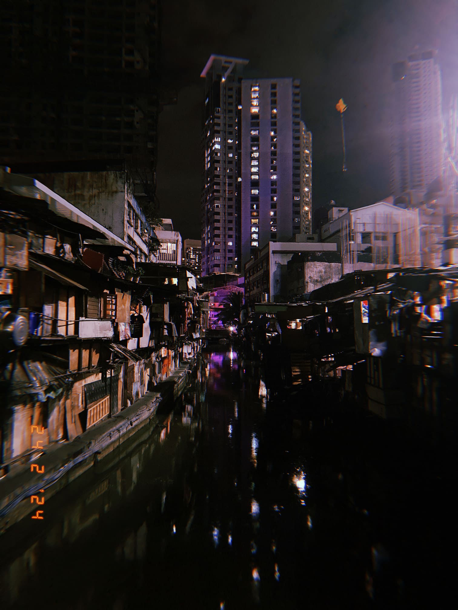 運河に映る夜景と高層ビル群（マニラ）