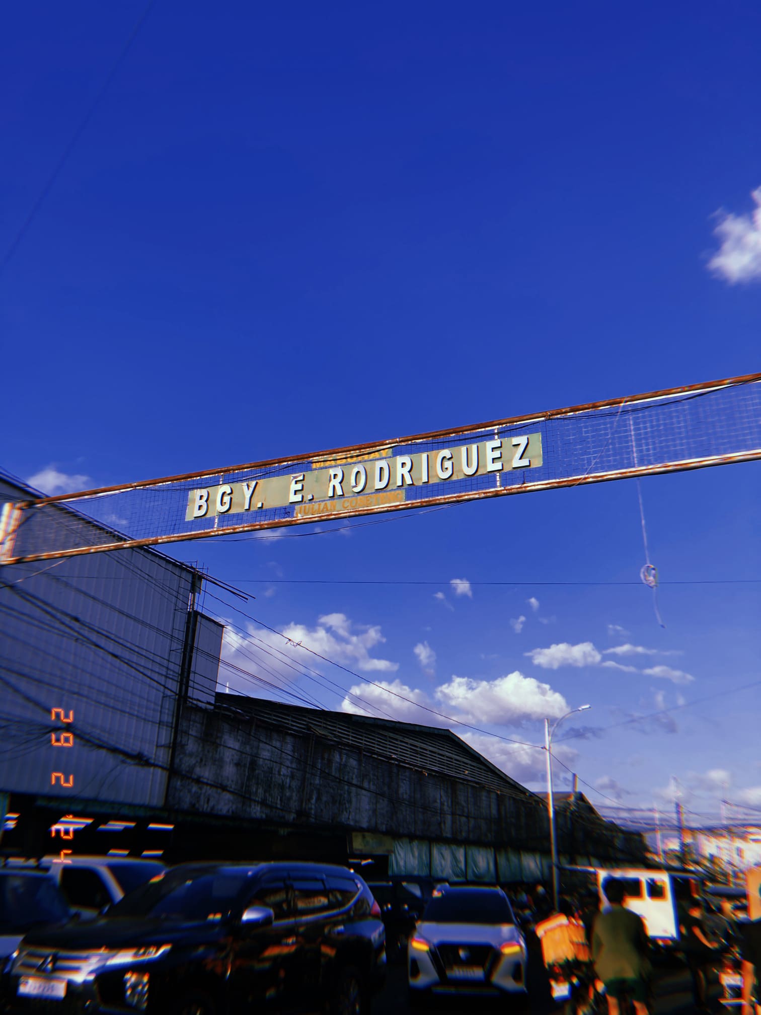 青空の下の古いサインボードと交通量（マニラ）