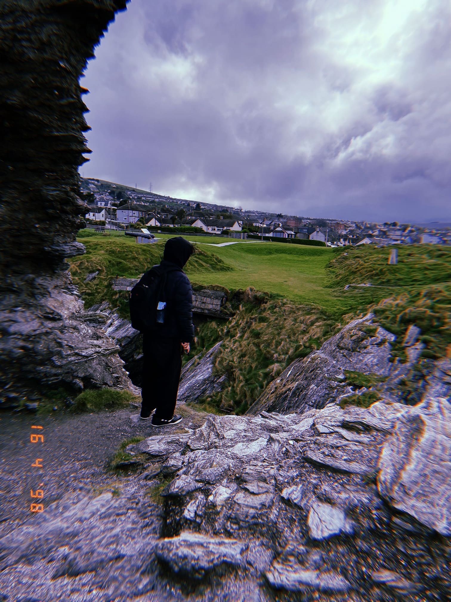 海沿いの遺跡で立つ人物の後ろ姿