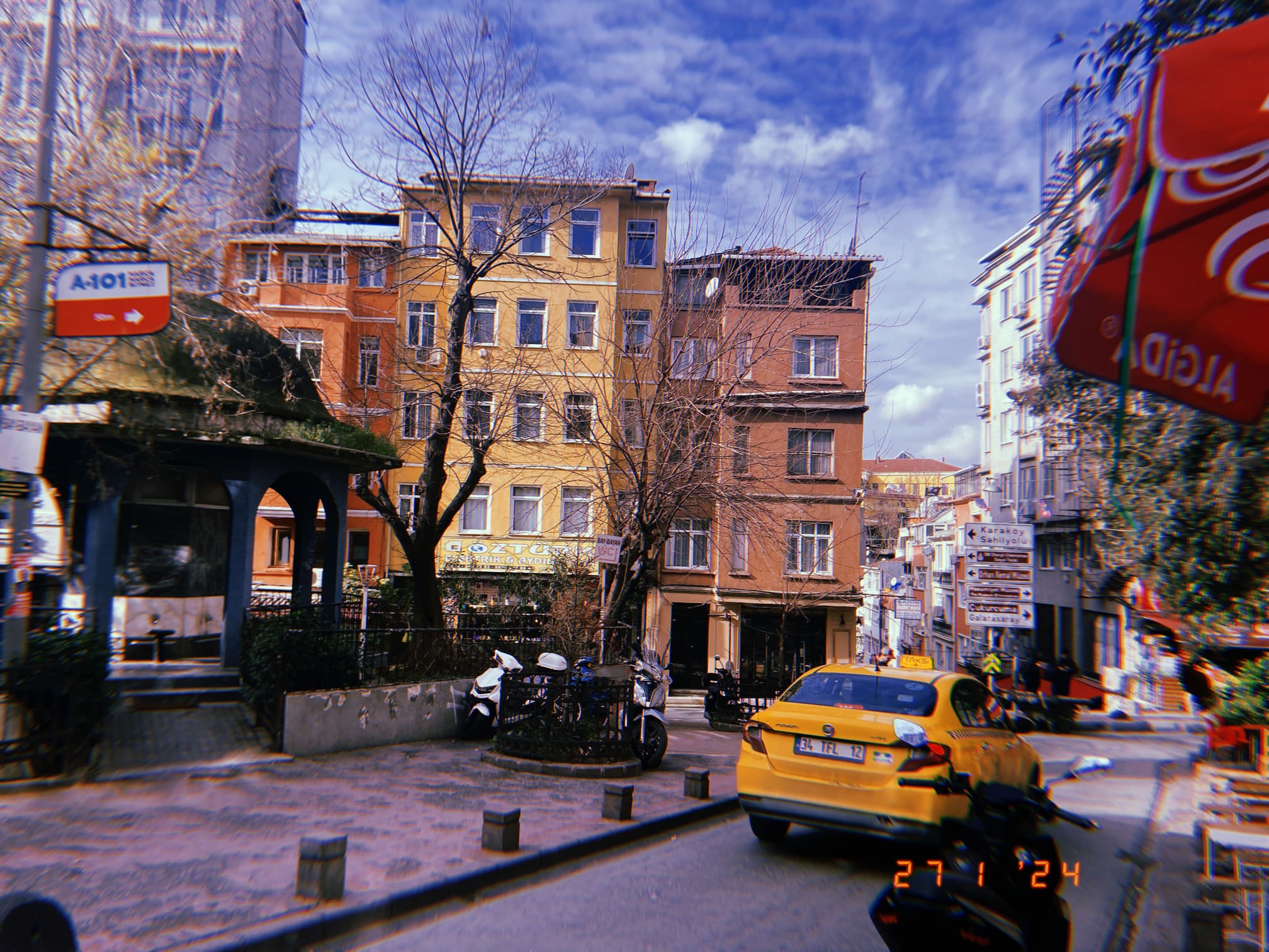 カラフルな建物の間を走るイスタンブールの黄色いタクシー